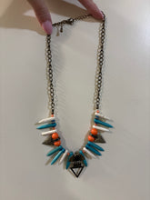 Load image into Gallery viewer, Bohemian-Style Statement necklace featuring tribal-inspired triangle pendants, pointed beads in white and turquoise, and orange accents on a bronze-toned chain
