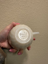 Load image into Gallery viewer, vintage 1940-1970s Fire-King white milk glass teacup, featuring the "Swirl" or "Golden Anniversary" pattern with 22k gold rim trim produced by Anchor Hocking coffee scented candle
