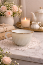 Load image into Gallery viewer, vintage 1940-1970s Fire-King white milk glass teacup, featuring the "Swirl" or "Golden Anniversary" pattern with 22k gold rim trim produced by Anchor Hocking coffee scented candle
